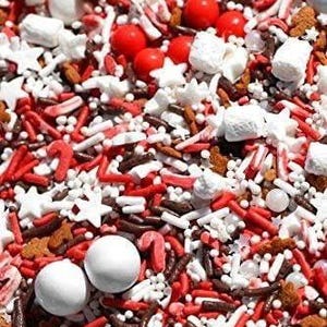May include: A close-up shot of a mix of festive sprinkles. The mix includes white round candies, red sprinkles, star-shaped sprinkles, and small brown sprinkles. The sprinkles are a mix of shapes and sizes, creating a textured and colorful appearance.