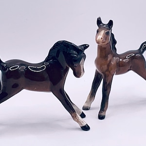 Op de afbeelding: Een witte keramische mok met een zwart handvat en de tekst "But First, Coffee" in een zwarte, vette letter. De mok staat op een wit oppervlak. De mok is 10 cm hoog.