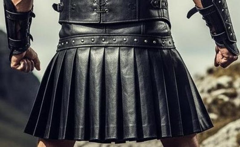 May include: A black leather kilt with pleated design. The kilt features a studded belt and is part of a leather outfit. The image shows a close-up of the kilt and the upper part of the outfit, suggesting a focus on alternative fashion or cosplay.