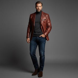 May include: A brown leather blazer with a quilted shoulder design. The blazer is paired with a dark gray turtleneck, blue jeans, and brown boots. The outfit is set against a gray backdrop.