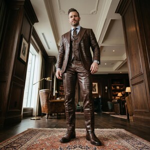 May include: A brown, textured leather suit, including a blazer, waistcoat, and trousers, is worn with a light blue shirt and brown tie. The suit has a crocodile skin pattern. Brown leather dress shoes complete the look.