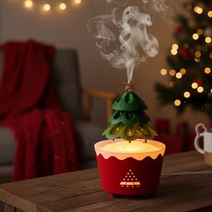Peut inclure: Un diffuseur d'huiles essentielles en forme de sapin de Noël, rouge et vert. Le diffuseur a une base rouge avec un bord festonné blanc et un sommet en forme de sapin vert. Il émet de la vapeur, et une petite étoile est au sommet. Sur une table en bois.
