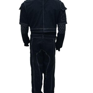 Puede incluir: Mono negro con costuras blancas. Presenta cuello alto, m&uacute;ltiples bolsillos y costuras decorativas en las mangas. El mono tiene cintur&oacute;n en la cintura y est&aacute; hecho de tela resistente.