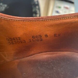 May include: Close-up of the inside of a brown leather shoe with the following text: 92412 583023 669 9 EX 71/02