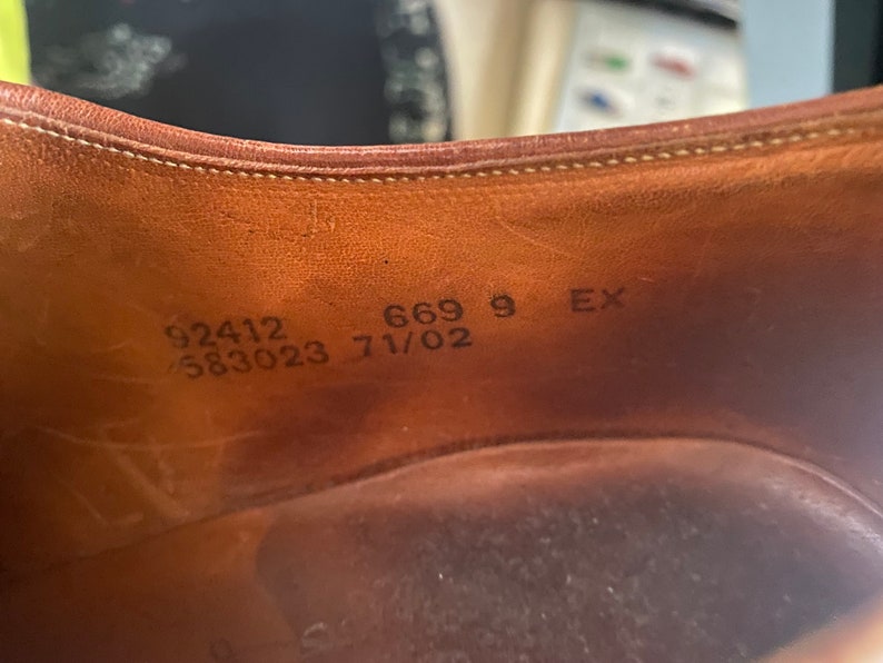 May include: Close-up of the inside of a brown leather shoe with the following text: 92412 583023 669 9 EX 71/02