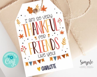 Puede incluir: Una etiqueta de regalo imprimible con temática otoñal para el Día de Acción de Gracias. La etiqueta tiene el texto "Estoy muy agradecido por los amigos como tú!" con un corazón y el nombre "Charlotte".