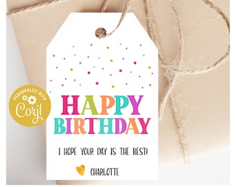 May include: A white gift tag with colorful confetti and the words "HAPPY BIRTHDAY" in bright letters. Below, it reads "I HOPE YOUR DAY IS THE BEST!" and "CHARLOTTE". The tag is tied to a wrapped gift with twine.