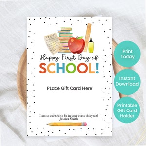 May include: A white gift card with black polka dots and the text "Happy First Day of SCHOOL!" in colorful letters. The card features watercolor illustrations of school supplies, including an apple, books, and a pencil. It says "Place Gift Card Here".