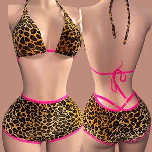 May include: A two-piece halter set with a leopard print design. The halter top and shorts are trimmed with bright pink. The text "Love a good halter" is displayed in a black rectangle at the top of the image.