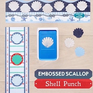 May include: A blue shell punch with a white shell design, accompanied by embossed scallop paper embellishments. The image also includes decorative paper strips with nautical themes and the text "Meet Me at the Shore."