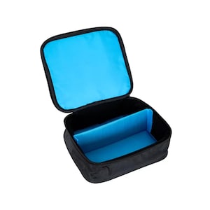 May include: Black, rectangular storage case with a zippered closure. The interior is lined with bright blue fabric and includes a blue divider. The case is open, revealing the interior.