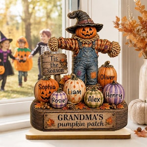 May include: A decorative tabletop figurine featuring a scarecrow with a pumpkin head wearing a hat and denim overalls. It is surrounded by several small pumpkins personalised with the names Sophia, Rosie, Liam, Alex, Oliver, and Henry.