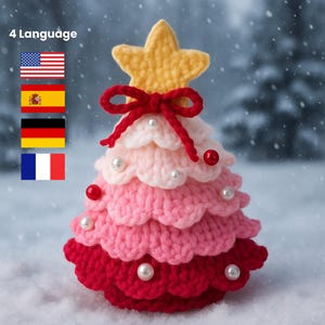 Peut inclure: Un sapin de Noël au crochet fait à la main, dans des tons de rouge, de rose et de blanc, surmonté d'une étoile jaune et d'un nœud rouge. L'arbre est orné de perles et de décorations rouges. Le texte "4 Language" et des drapeaux sont inclus.