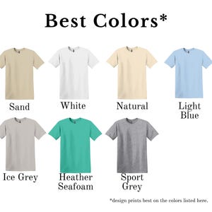 May include: A selection of eight short-sleeved t-shirts in various colors, including sand, white, natural, light blue, ice grey, heather seafoam, and sport grey. The text "Best Colors" is at the top, with a note at the bottom about design prints.