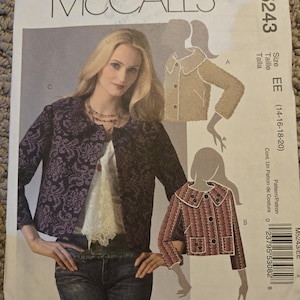 May include: McCall's sewing pattern M5243 showing a woman in a jacket. The pattern includes illustrations of different jacket styles, with size EE (14-16-18-20) indicated. The pattern's cover has the McCall's logo.