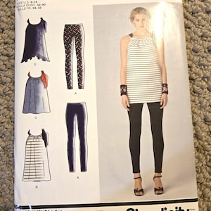 May include: A Cynthia Rowley Simplicity sewing pattern, size U.S. 6-14, featuring designs for tops and leggings. The cover shows a woman wearing a striped top and black leggings. The pattern includes various top styles and leggings.