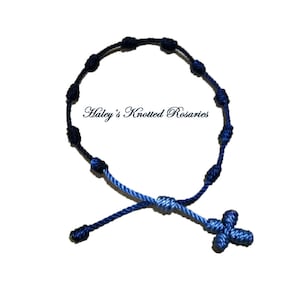 May include: A blue and black knotted rosary bracelet with a blue cross charm. "Haley's Knotted Rosaries" is written in white text on a white background.