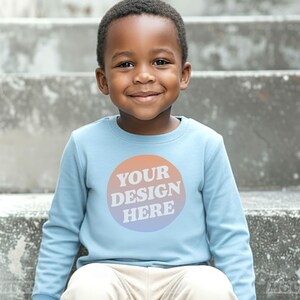 Mockup Rabbit Skins 3302 Toddler Youth Long Sleeve T-shirt in Light Blue with Boy model front view