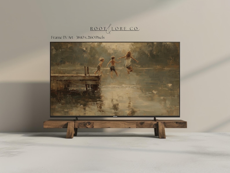 Puede incluir: Un televisor de pantalla plana grande que muestra una pintura de tres ni&ntilde;os saltando al agua desde un muelle de madera. El televisor est&aacute; montado en un soporte de madera r&uacute;stico. El texto "ROOT & LORE CO." y "Frame TV Art - 3840 x 2160 Pixels" son visibles.