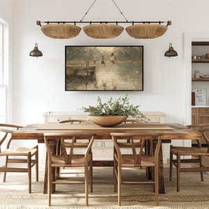 Puede incluir: Un comedor con una mesa de madera y sillas, una alfombra tejida y una pintura enmarcada. Encima de la mesa cuelga una l&aacute;mpara con tres pantallas en forma de cestas tejidas. La habitaci&oacute;n tiene paredes blancas y una paleta de colores neutros.