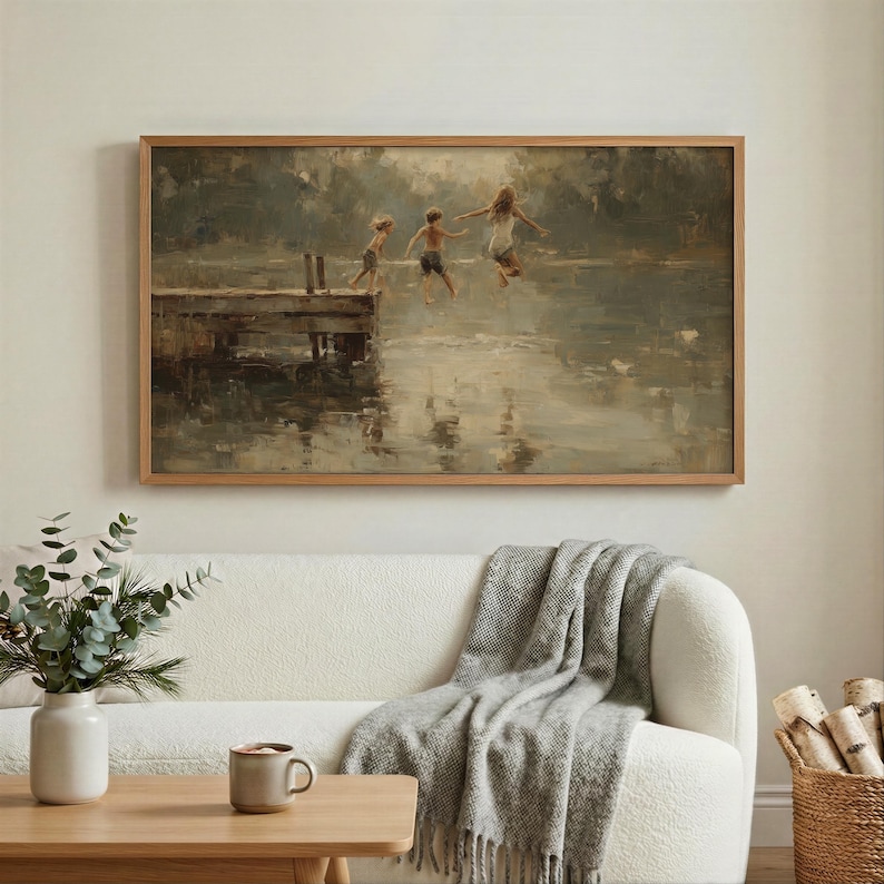 Puede incluir: Una obra de arte enmarcada representa a tres ni&ntilde;os saltando al agua desde un muelle de madera. La pintura tiene una paleta de colores apagados, con un enfoque en los reflejos del agua y el movimiento de las figuras. El marco es de color marr&oacute;n claro.