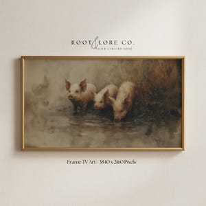 Op de afbeelding: Een ingelijst kunstwerk met drie varkens in een gedempte, vintage stijl. De varkens worden afgebeeld in een ondiep water, met zachte, aardse tinten die de scène domineren. De lijst is goudkleurig en het kunstwerk is getiteld "Frame TV Art - 3840 x 2160 Pixels".