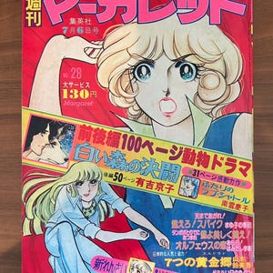 Puede incluir: Una portada de revista manga japonesa vintage con un fondo rojo e ilustraciones de mujeres de estilo anime. El título de la revista está en letras rosas grandes, con texto japonés y el precio 130 yenes.