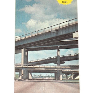 May include: A vintage Conoco road map for Baton Rouge, Louisiana. The map features a photo of a highway overpass with a blue sky and white clouds in the background. The text "Plus 4 exciting Weekend Touraide Trips" is printed in a yellow circle on the map.
