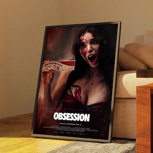 Puede incluir: Un póster de película enmarcado para "Obsesión" que muestra a una mujer con sangre en la cara y el pecho, gritando. El póster incluye el texto "One Wish Willow" y "Obsesión" en letras blancas grandes. El póster está en un marco negro.