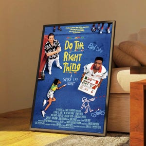 Puede incluir: Póster enmarcado de la película "Do the Right Thing" de Spike Lee. El póster presenta un fondo azul con el título de la película en letras grandes y coloridas. Se incluyen imágenes de actores e ilustraciones.