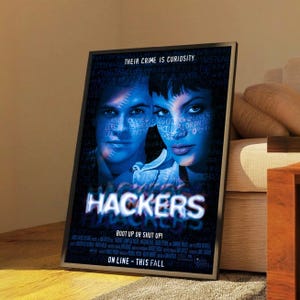 May include: A framed movie poster for the film "Hackers" with two actors in blue tones. The poster includes the text "THEIR CRIME IS CURIOSITY" and the film title "HACKERS" in large, glowing letters. The tagline "BOOT UP OR SHUT UP!" is also visible.