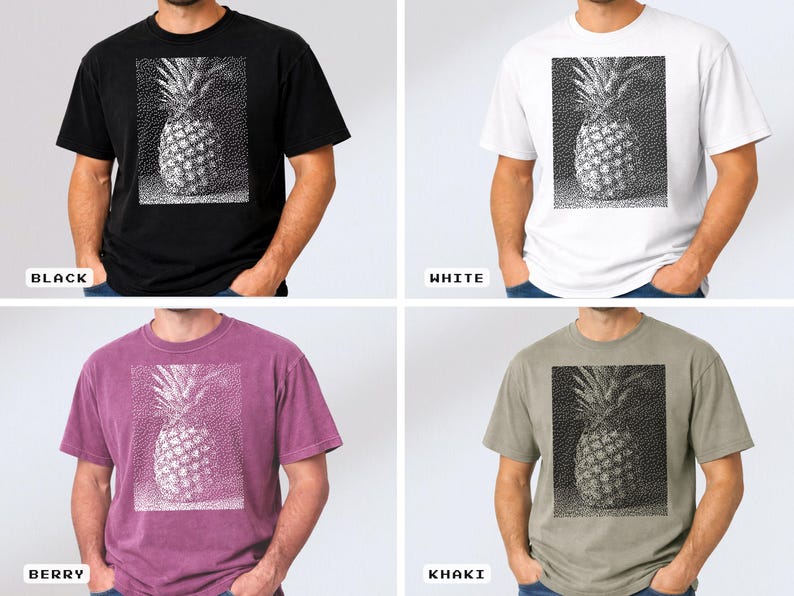 May include: A black, white, berry, and khaki t-shirt featuring a detailed pineapple graphic. The pineapple design is in a rectangular frame. The shirts are short-sleeved and made of a soft material.