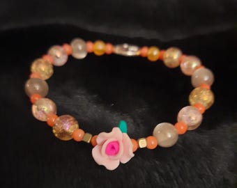 Pulsera reversible con dije de cuentas (rosa y símbolo de la paz)