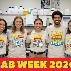 Puede incluir: Cinco personas con camisetas beige con dise&ntilde;os coloridos de "LAB WEEK" y el a&ntilde;o 2026. Las camisetas presentan personajes de dibujos animados y gr&aacute;ficos relacionados con el laboratorio. El texto "LAB WEEK 2026" est&aacute; en rojo en la parte inferior.