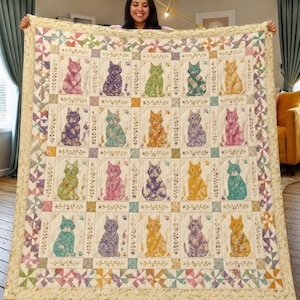 May include: A large, quilted blanket featuring a repeating pattern of colorful cat illustrations. Each cat is depicted in a unique floral design, set against a cream-colored background. The quilt has a decorative border with geometric and floral patterns.