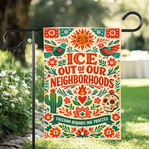 Op de afbeelding: Een decoratieve tuinvaandel met een crèmekleurige achtergrond en kleurrijke bloemen- en vogelontwerpen. De vlag toont de tekst "ICE OUT OF OUR NEIGHBORHOODS" en "FREEDOM REQUIRES DUE PROCESS". Een zon, cactus en schedel zijn ook afgebeeld.