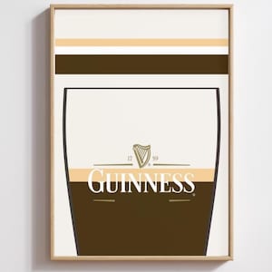 Op de afbeelding: Een ingelijste print met een gestileerd Guinness pintglasontwerp. Het kunstwerk heeft een bruin en beige kleurenschema met het Guinness-logo. De print heeft een lichtbeige achtergrond met bruine en gouden horizontale strepen. Pub-thema.