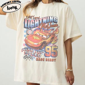 Puede incluir: Camiseta de color marfil con un dise&ntilde;o de Rayo McQueen de la pel&iacute;cula Cars. El dise&ntilde;o incluye el texto "Street Legend Lightning McQueen", "Need for Speed" y "Race Ready" con el n&uacute;mero "95".