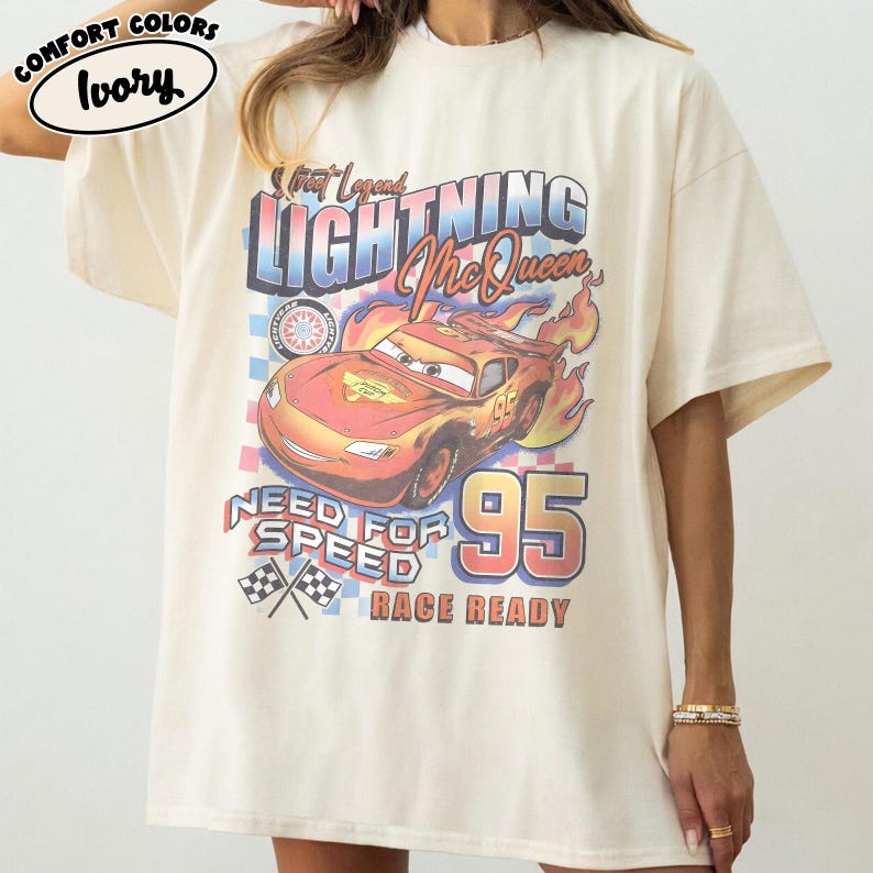 Puede incluir: Camiseta de color marfil con un dise&ntilde;o de Rayo McQueen de la pel&iacute;cula Cars. El dise&ntilde;o incluye el texto "Street Legend Lightning McQueen", "Need for Speed" y "Race Ready" con el n&uacute;mero "95".