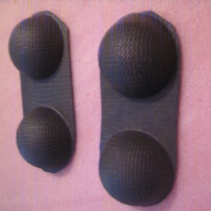 May include: Two black rubber pads with a textured surface. Each pad has two raised, round, textured bumps.