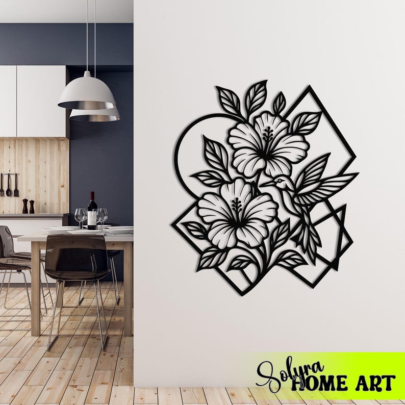 May include: Black metal wall art featuring a floral design with hibiscus flowers, leaves, and a hummingbird. The artwork is set within geometric shapes, including a circle and a diamond. The text "Solyra HOME ART" is at the bottom.