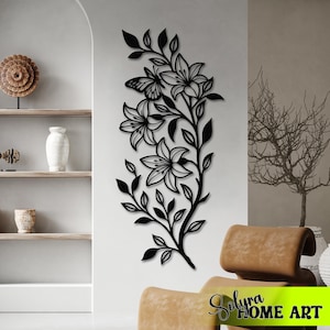 Puede incluir: Arte mural de metal negro con un dise&ntilde;o floral de lirios y una mariposa. La obra de arte est&aacute; montada en una pared blanca, ofreciendo una est&eacute;tica moderna. Un elemento decorativo para la decoraci&oacute;n del hogar.