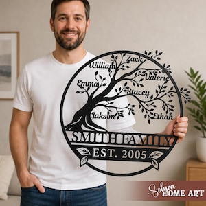 Könnte beinhalten: Ein Wandkunstwerk aus schwarzem Metall mit einem Familienstammbaum. Das Baumdesign zeigt einen kreisförmigen Rahmen mit dem Familiennamen "SMITH FAMILY" und dem Gründungsjahr "EST. 2005". Einzelne Namen sind auf den Ästen platziert.