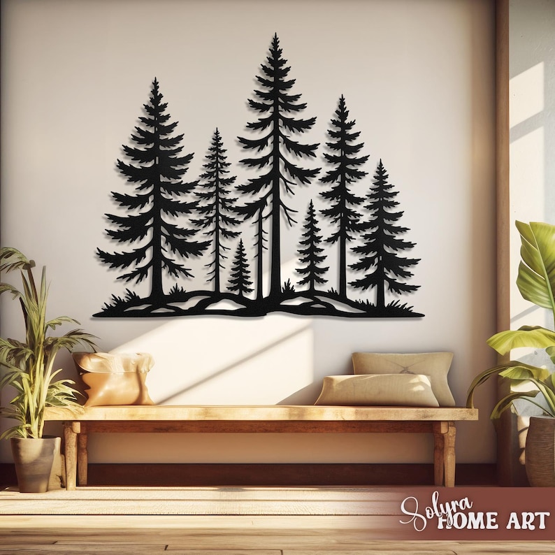 May include: Black metal wall art depicting a forest scene with several pine trees of varying sizes. The artwork is mounted on a white wall above a wooden bench with pillows. The overall theme is nature and home decor.