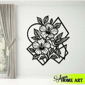 May include: Black metal wall art featuring a floral design with hibiscus flowers and a hummingbird. The artwork is set against geometric shapes and includes the text "Solyra HOME ART" in a neon green rectangle.
