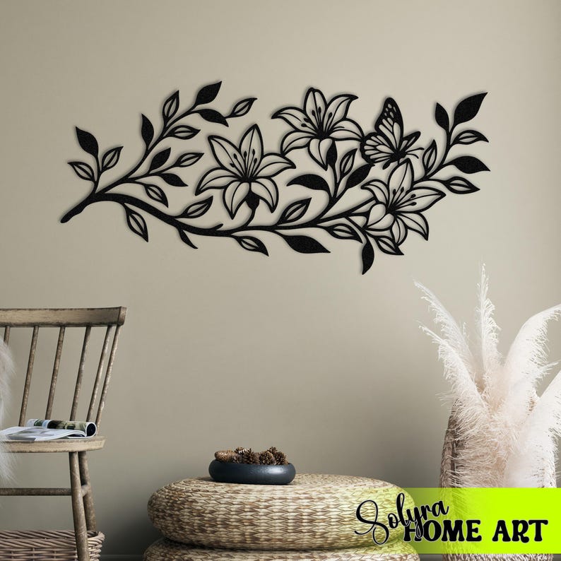 Puede incluir: Arte mural floral de metal negro con lirios y una mariposa. El dise&ntilde;o incluye hojas y tallos, creando una est&eacute;tica inspirada en la naturaleza. Adecuado para la decoraci&oacute;n interior del hogar.