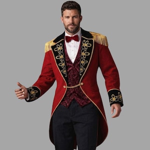 Op de afbeelding: Een rode rokkostuumjas met zwarte revers met gouden borduursels, gouden franje-epauletten en gouden manchetten. Het ensemble bevat een donkerrood vest met patroon, een wit overhemd, een donkerrode vlinderdas en een donkergrijze broek.