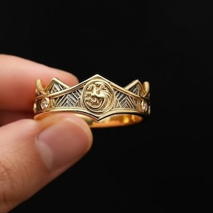 May include: A white ceramic mug with a black handle and the text "But First, Coffee" in a handwritten style. The mug is on a white surface. The mug is approximately 4 inches tall.