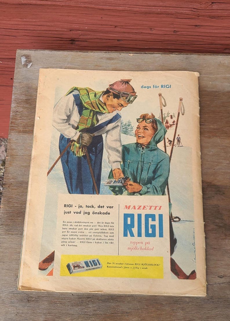 Puede incluir: Un anuncio vintage de chocolate RIGI con una ilustraci&oacute;n de dos esquiadores con ropa de invierno. El texto incluye 'dags f&ouml;r RIGI', 'MAZETTI RIGI' y 'toppen p&aring; mj&ouml;lkchoklad' junto a un p&aacute;rrafo promocional y una imagen de una tableta.