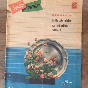 Puede incluir: Una revista vintage titulada Familie Journalen con una ilustraci&oacute;n central de una bandeja de plata llena de capullos de rosa rosados. La portada incluye texto en sueco, un fondo de rayas azules horizontales y un precio de 45 &ouml;re de marzo de 1953.